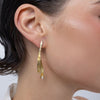 Pixie Earrings on model, handmade brass long earrings worn on ear showing length and graceful movement