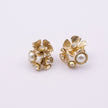 A pair of gold-toned flower-shaped stud earrings with white pearl accents and small clear rhinestones, displayed on a clean white background.