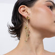 Handmade brass cascading floral drop earring with amethyst crystal, worn on ear