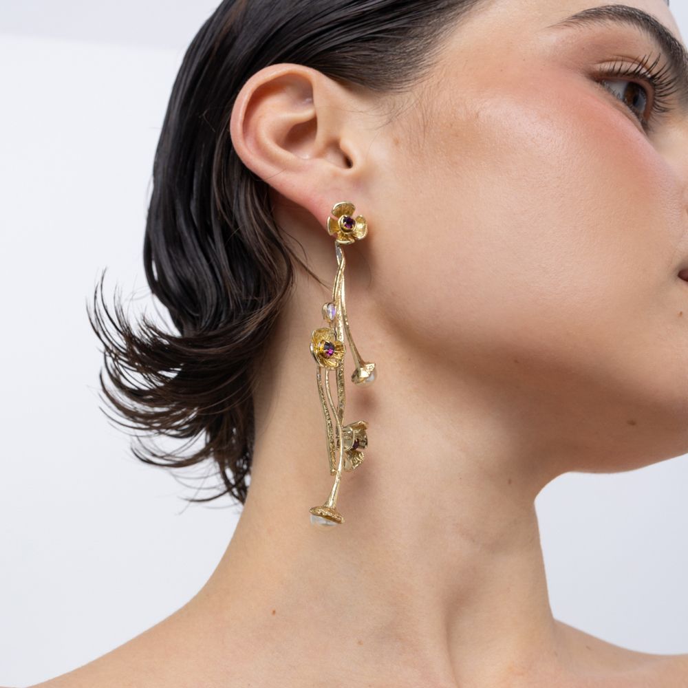 Handmade brass cascading floral drop earring with amethyst crystal, worn on ear