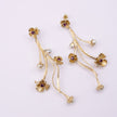Brass long drop earrings pair with amethyst flowers and pearl buds, product shot