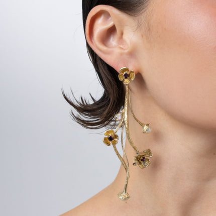 Handmade brass layered floral drop earring with amethyst crystal, worn on ear
