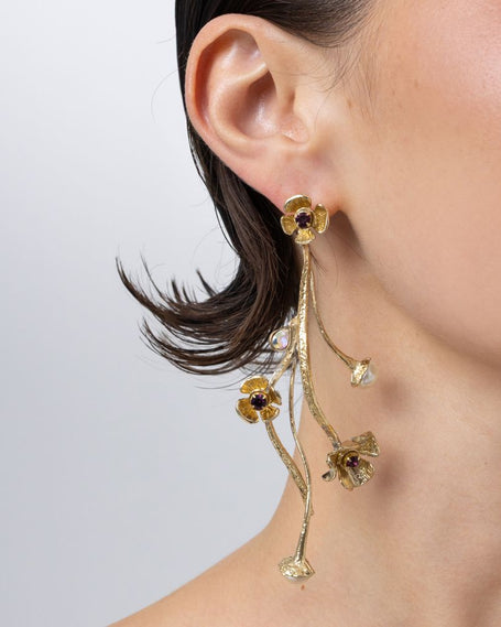 Handmade brass layered floral drop earring with amethyst crystal, worn on ear