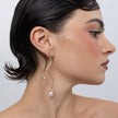 Handmade brass double pearl drop earring worn on ear, side profile,