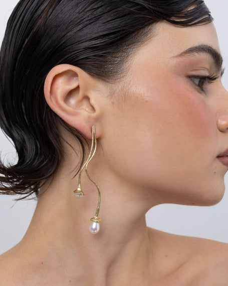 Handmade brass double pearl drop earring worn on ear, side profile,