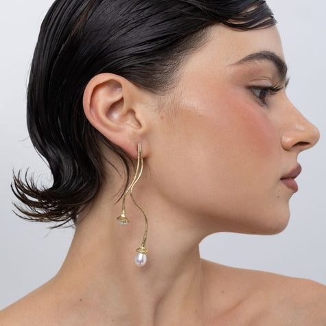 Handmade brass double pearl drop earring worn on ear, side profile,
