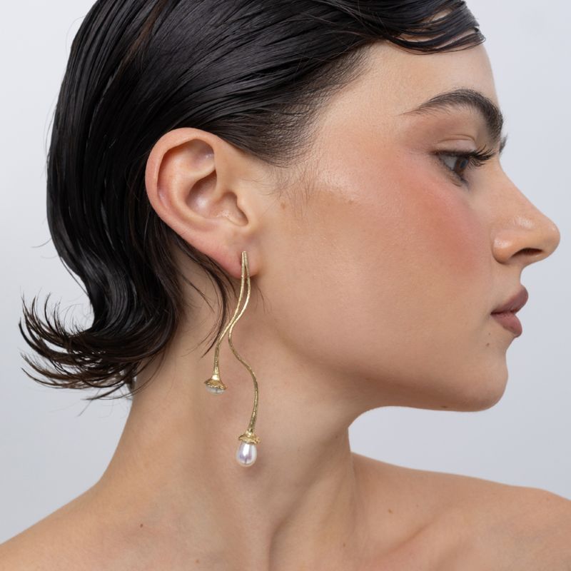 Handmade brass double pearl drop earring worn on ear, side profile,