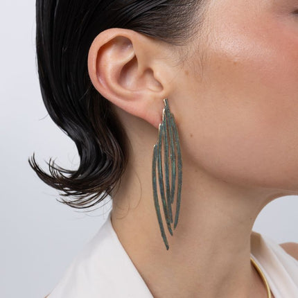 Pine Earrings on model, handmade brass long feather earrings worn on ear showing length and movement
