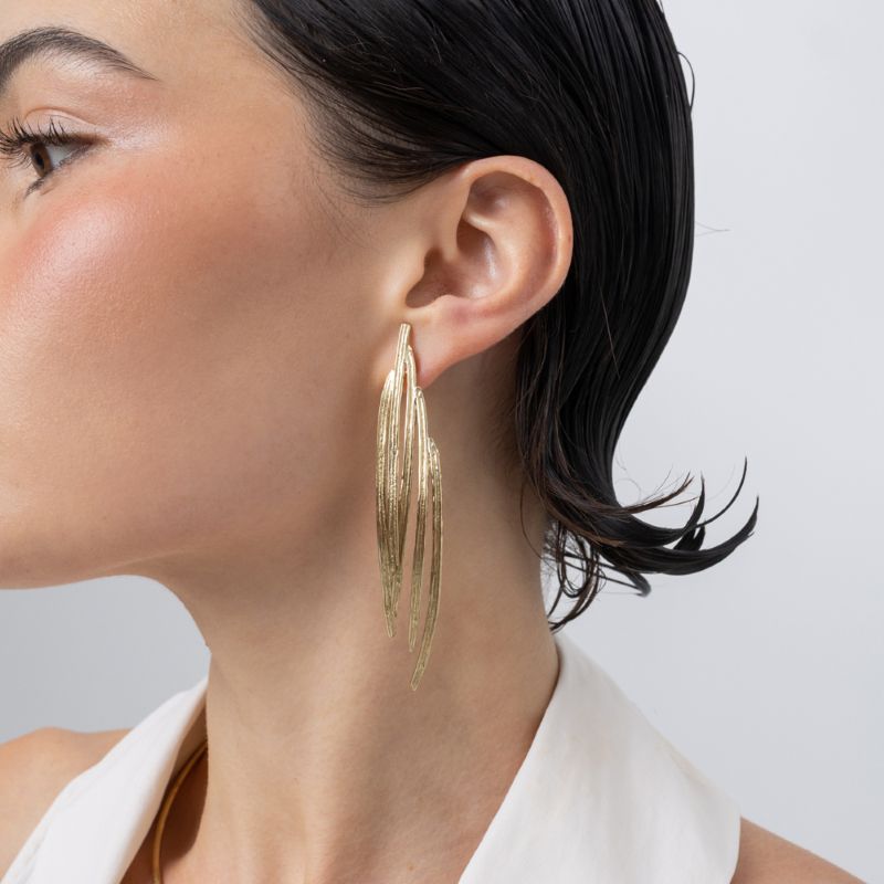 Pine Earrings, handmade brass long drop earrings with layered peacock feather blades and etched texture on model
