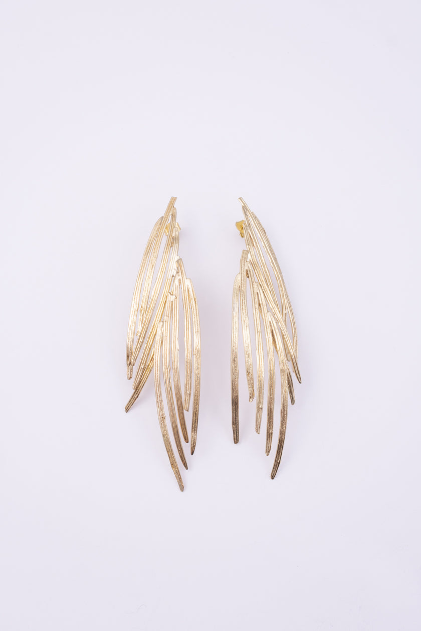 Double Pine Earrings, handmade brass long drop earrings with layered peacock feather blades and etched texture on white background