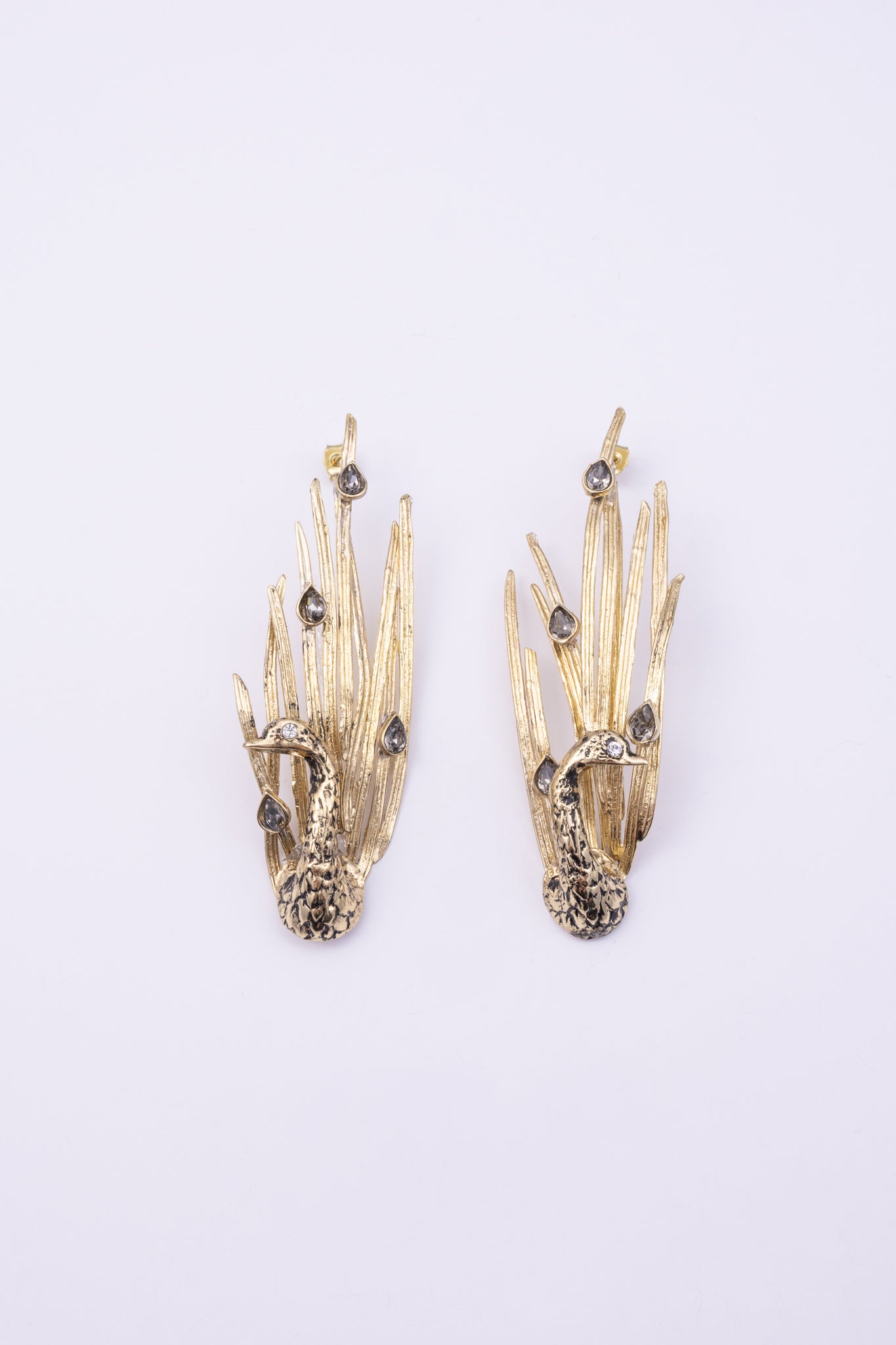 Peacock Earrings side view, handmade brass sculptural earrings with hammered bird body and layered feather plumage
