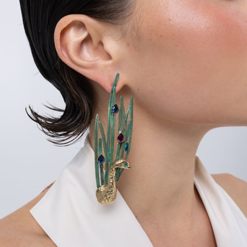 Peacock Earrings on model, handmade brass long drop earrings with sculpted bird and feather blades worn on ear showing length and movement