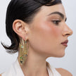 Peacock Earrings on model side view, handmade brass statement earrings with textured peacock body and teardrop crystals framing the jawline
