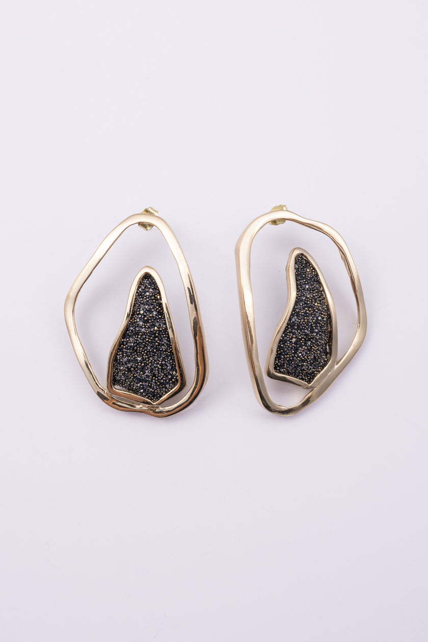 Shimmer Earrings angle view: handmade brass sculptural earrings with overlapping rippled frame