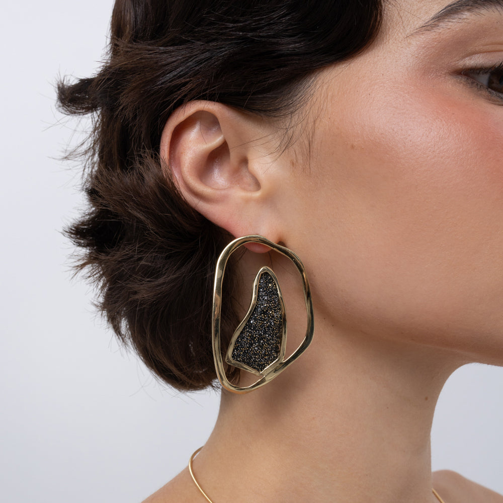 Shimmer Earrings on model: handmade brass sculptural earrings with open organic frame and crystal shard
