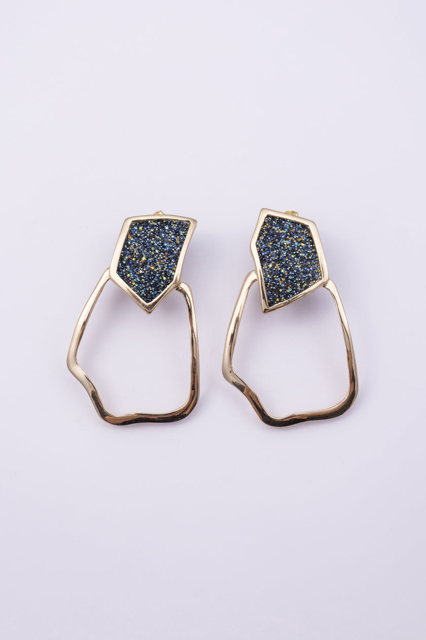 Glow Earrings on white background: handmade brass statement earrings with crystal shard and open organic drop