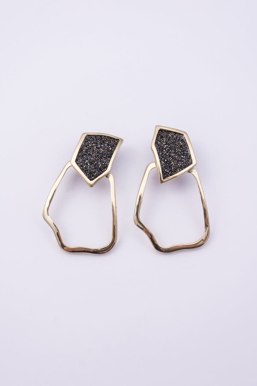 Glow Earrings front view: handmade brass geometric earrings with faceted crystal stud and irregular loop
