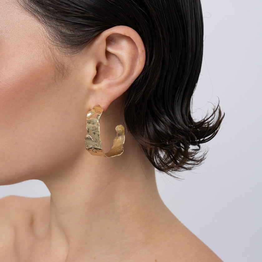 Ripple Hoop Earrings on model, handmade brass wide hoop earrings worn on ear showing scale and rippled texture
