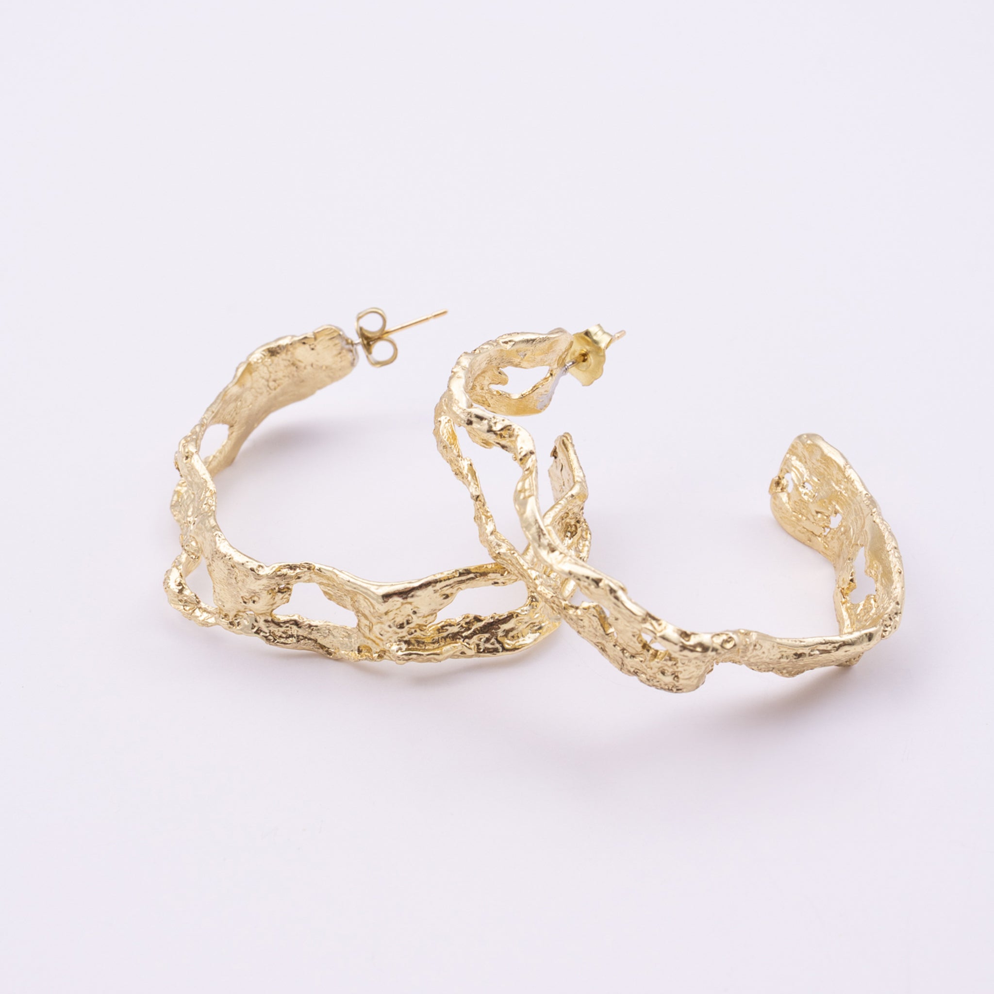 Lichen Hoop Earrings close up, handmade brass earrings with pierced molten texture and post fastening