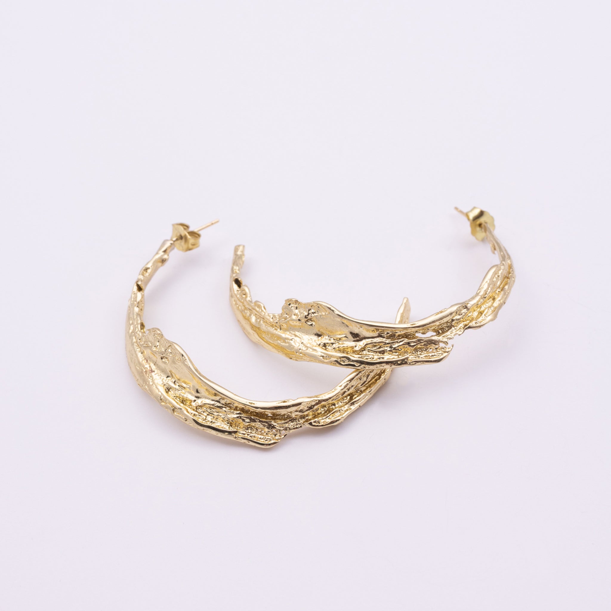 Willow Hoop Earrings close up, handmade brass earrings with molten bark texture and post fastening