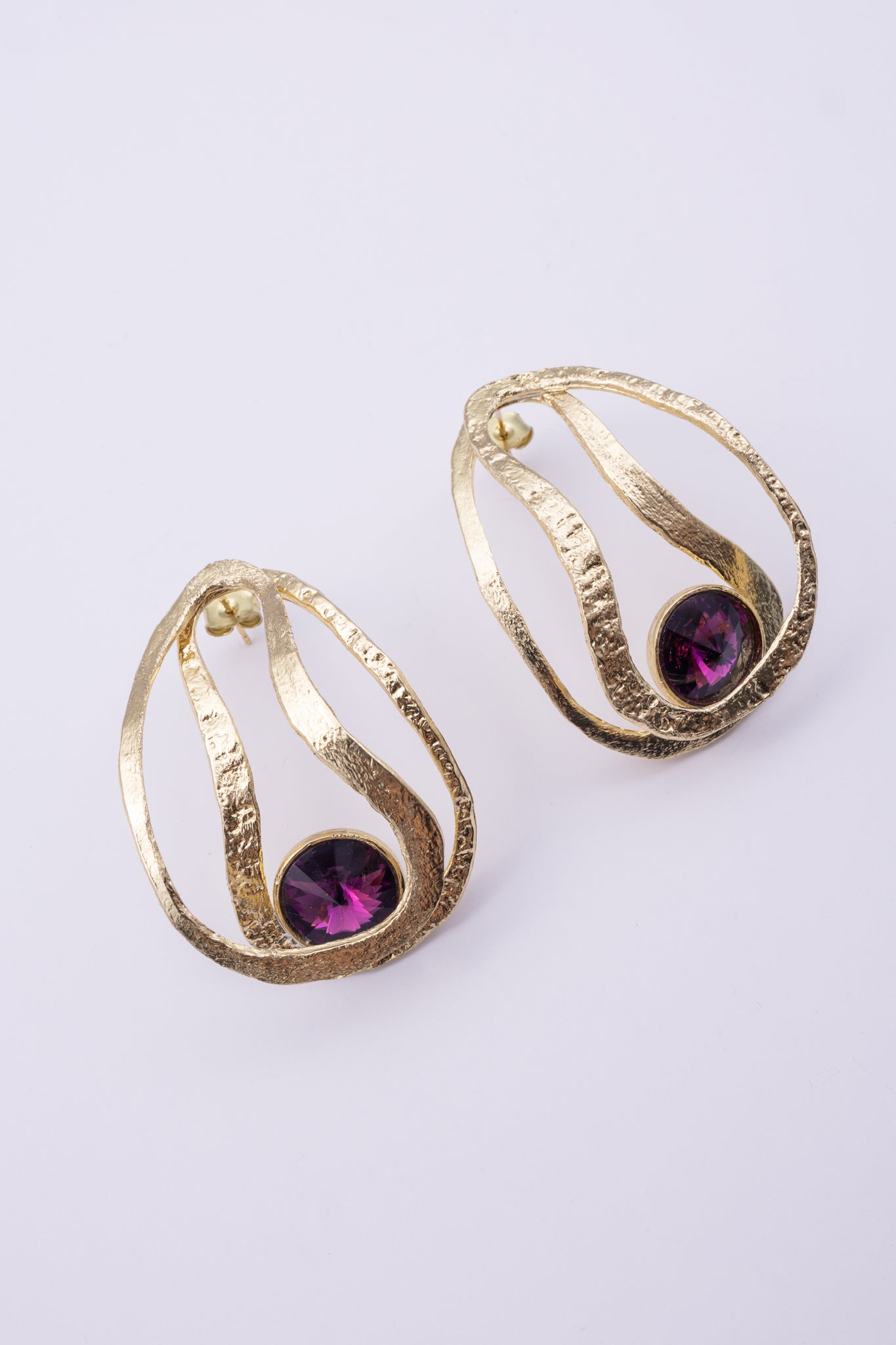 Boteh Earrings, handmade brass teardrop earrings with looping hammered ribbons and round crystal on white background