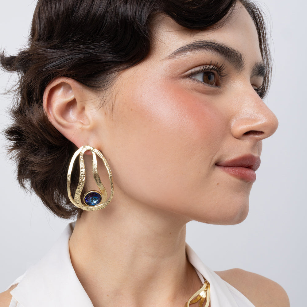 Boteh Earrings on model side view, handmade brass openwork earrings with looping textured ribbons and faceted crystal
