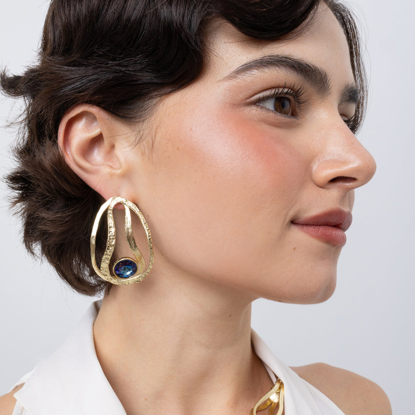 Boteh Earrings on model side view, handmade brass openwork earrings with looping textured ribbons and faceted crystal
