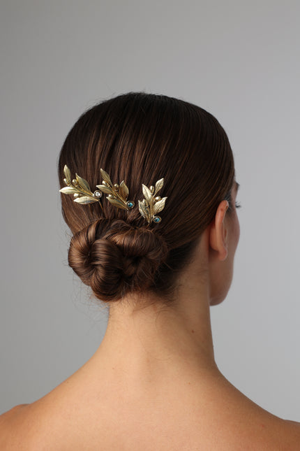 Handcrafted gold-plated hair pin with sculpted olive leaf design and subtle crystal accents, inspired by Greek symbolism.