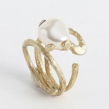 Close-up product shot of handmade textured brass adjustable twig ring with baroque pearl centerpiece — Sec Ring by Kalliope Jewelry, crafted in Greece